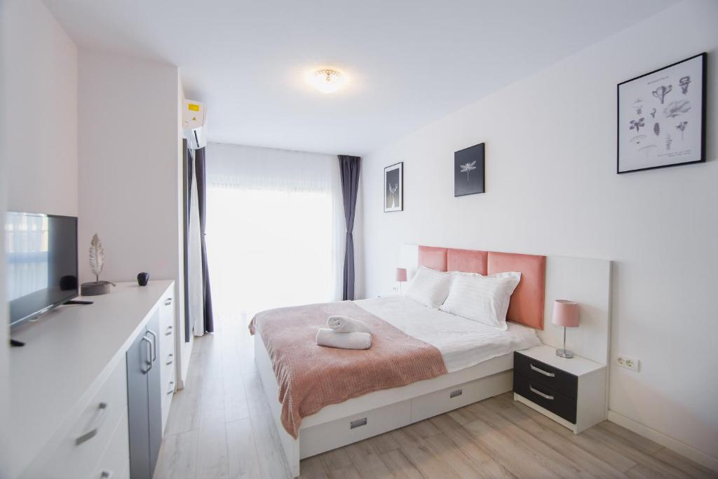 a white bedroom with a bed and a sink at Pinky Black Escape in Oradea