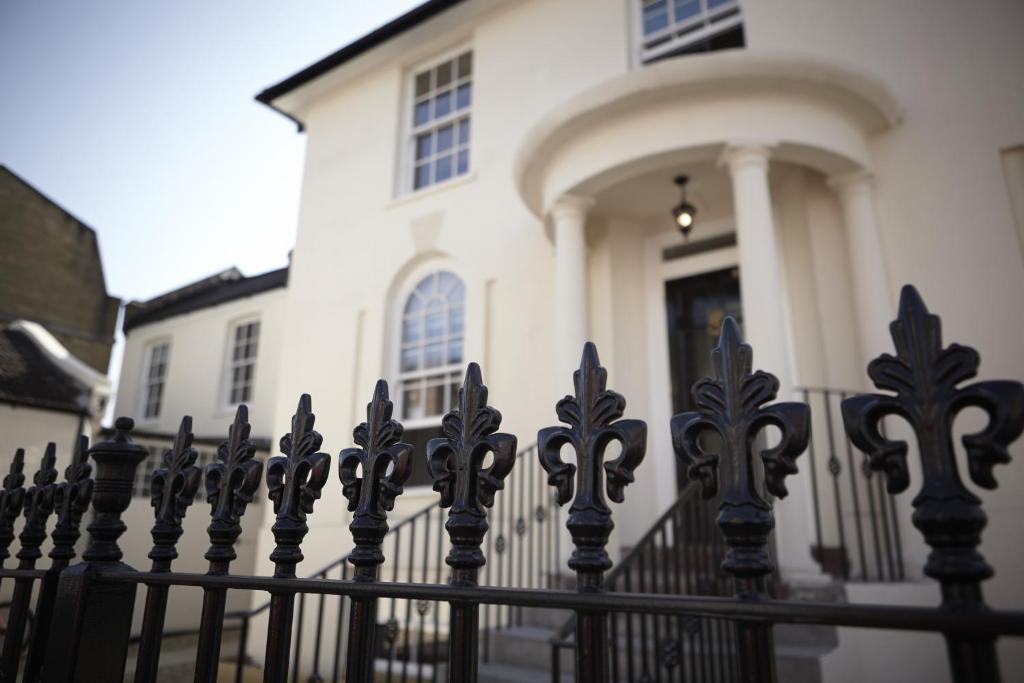 a black fence in front of a white house at Park Villa Boutique Hostel in London