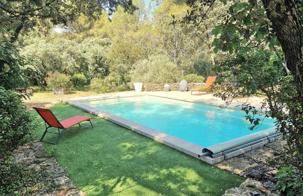- une piscine avec une chaise dans la cour dans l'établissement Mas Provençal avec piscine., à Grans