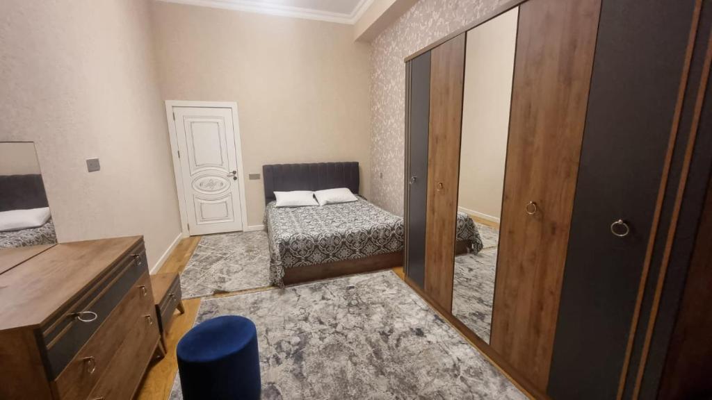 a small bedroom with a bed and a dresser at Kristal Sumqayıt in Sumqayıt