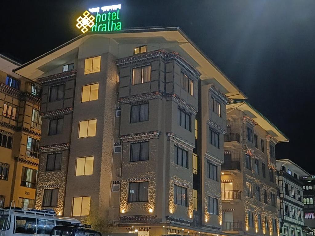 a building with a neon sign on top of it at Hotel Dralha in Thimphu