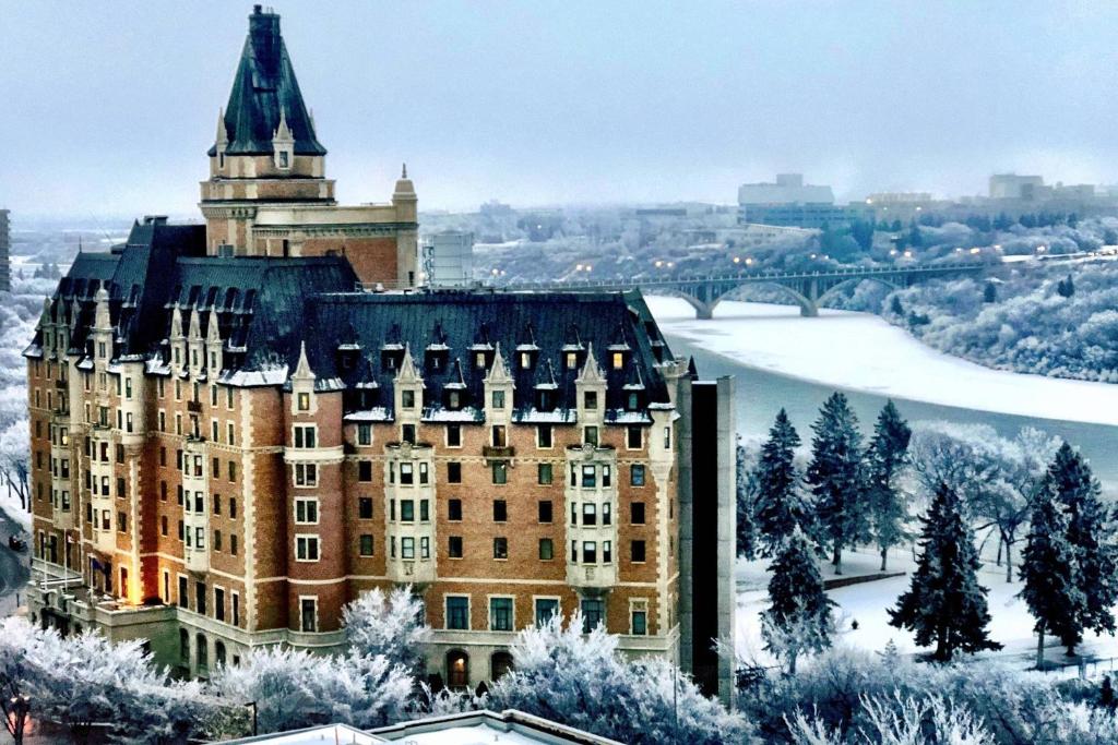 a large building with a tower in the snow at Delta Hotels by Marriott Bessborough in Saskatoon