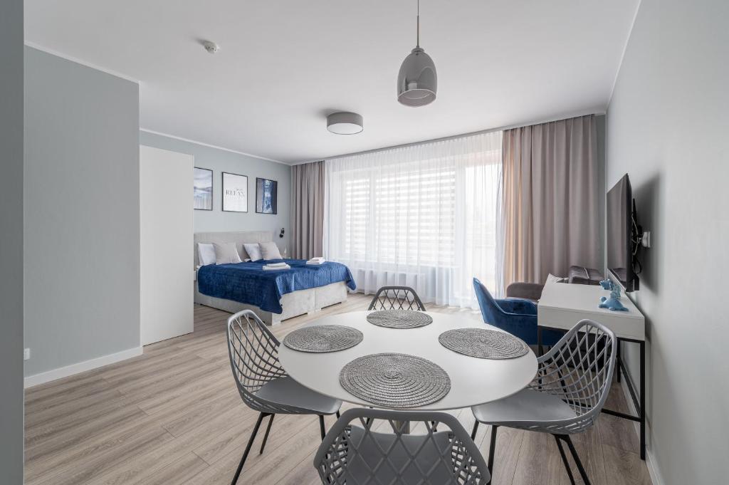 a living room with a table and chairs and a bedroom at Apartamenty Sunline Kołobrzeg in Kołobrzeg