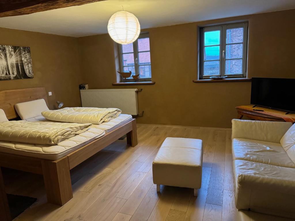 una camera con due letti, un divano e un pianoforte di Schöneberger Bauernhof - Hühnerhaus a Schöneberg