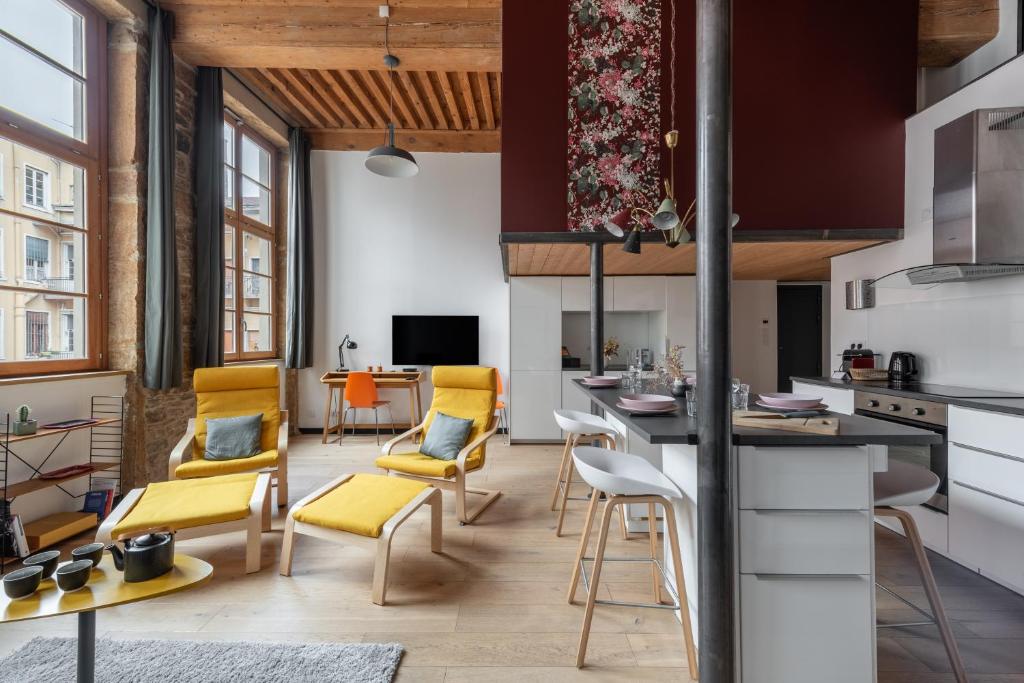 d'une cuisine et d'un salon avec des chaises jaunes et un comptoir. dans l'établissement La Bohème - Au coeur de la Croix-Rousse, à Lyon