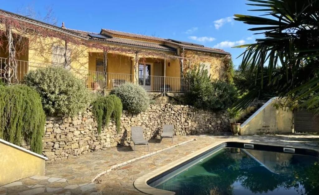 uma casa com piscina em frente a um edifício em Villa de 4 chambres avec piscine privee jardin clos et wifi a Generargues em Générargues