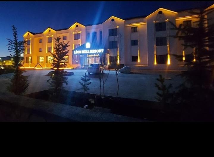 een groot wit gebouw met 's nachts verlichting bij LİON HİLL RESORT in Sarıkamıs
