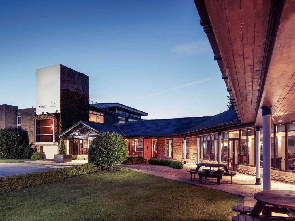 un edificio con una mesa de picnic delante de él en Jupiter Hotel Wetherby, en Wetherby