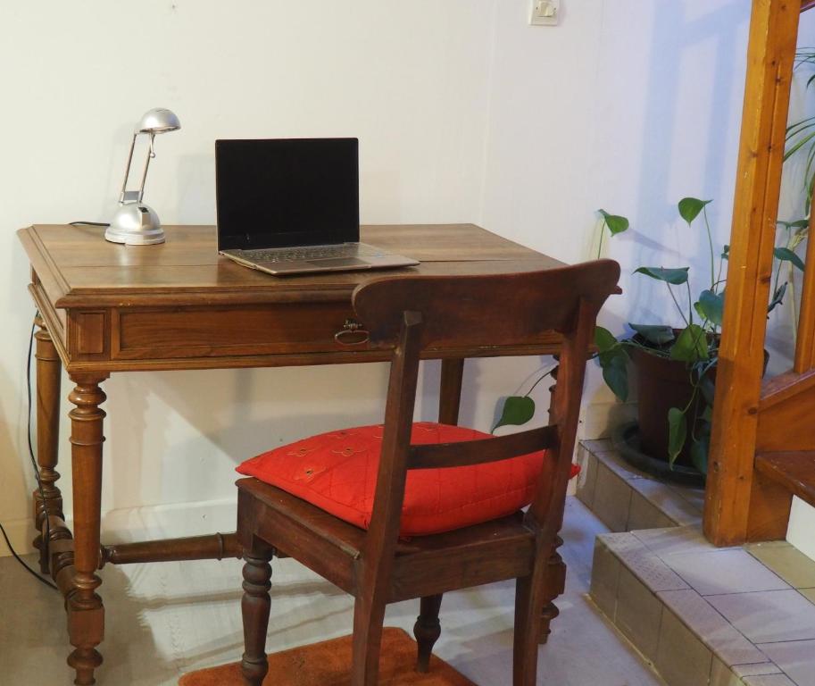 a wooden desk with a laptop computer on top of it at Gencay La maison blanche in Gençay