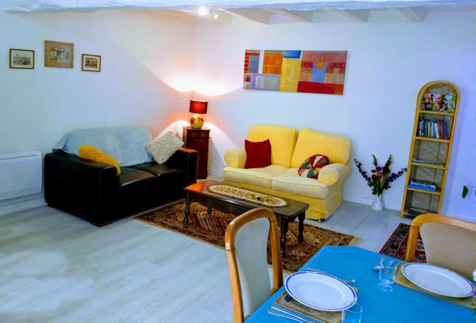 uma sala de estar com um sofá e uma mesa em Gencay La maison blanche em Gençay
