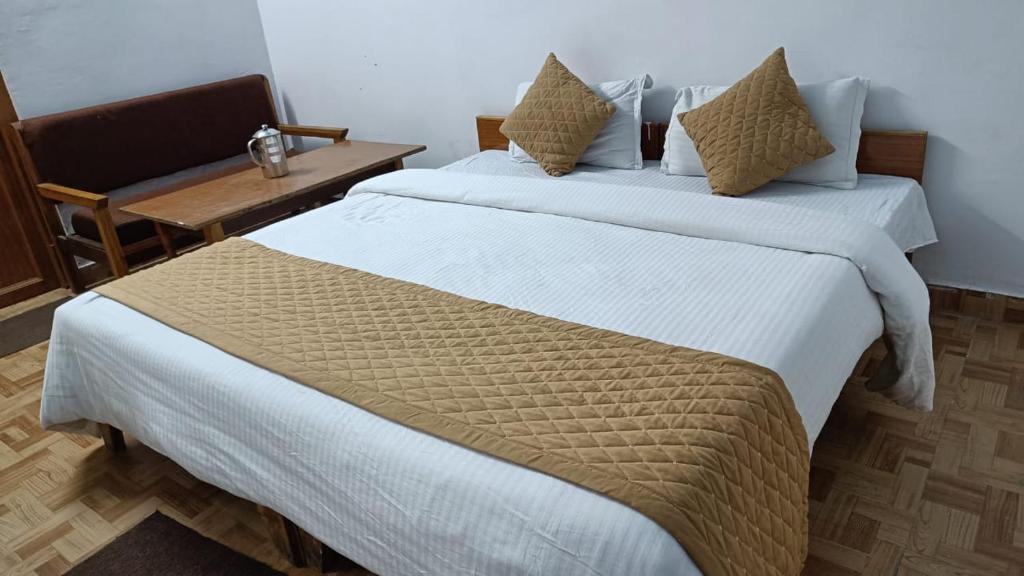 a hotel room with two beds and a chair at Phoenix Hotel & Restaurant in Kota Bāgh