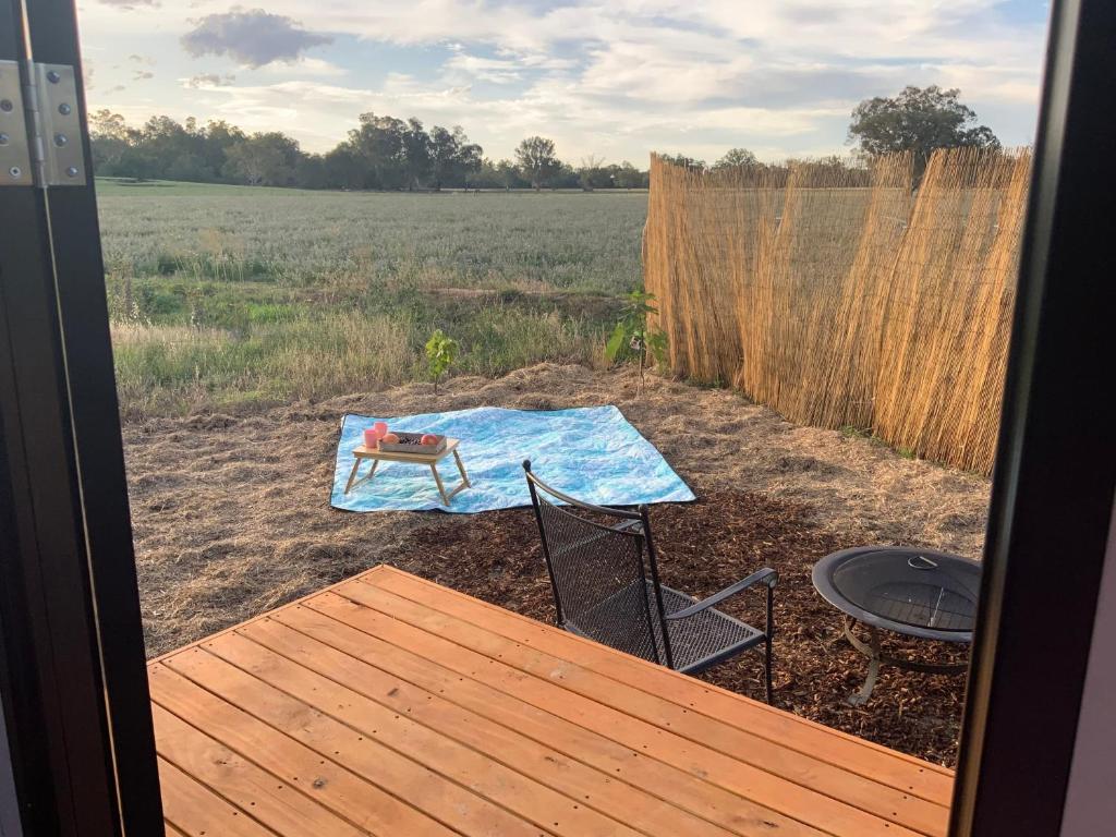 a patio with a table and chairs and a grill at Starry Night Farmstay in Forbes