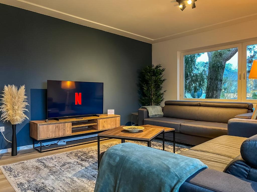 a living room with a tv and a couch at Kokomani Living Wetzlar in Wetzlar