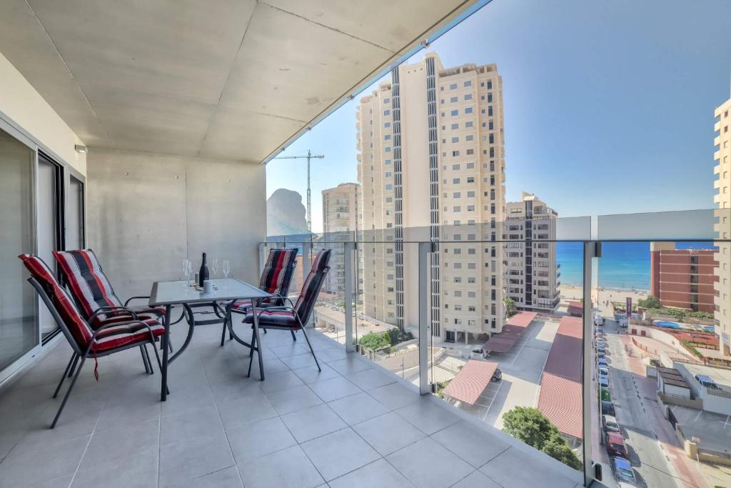a balcony with a table and chairs and a view of the city at Apartamento Mirador - PlusHolidays in Calpe