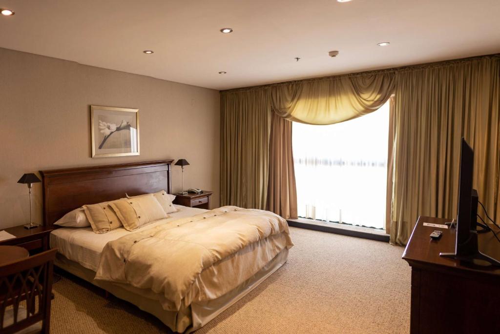 聖薩爾瓦多德胡胡伊的住宿－胡胡伊豪生大酒店，一间卧室设有一张大床和一个大窗户