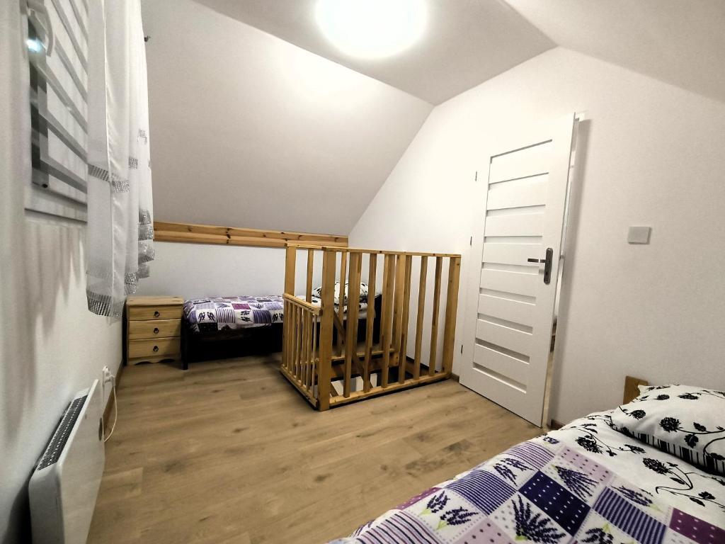 um quarto com uma cama e um berço em Holiday House Lawendowa Przystań em Miszkowice