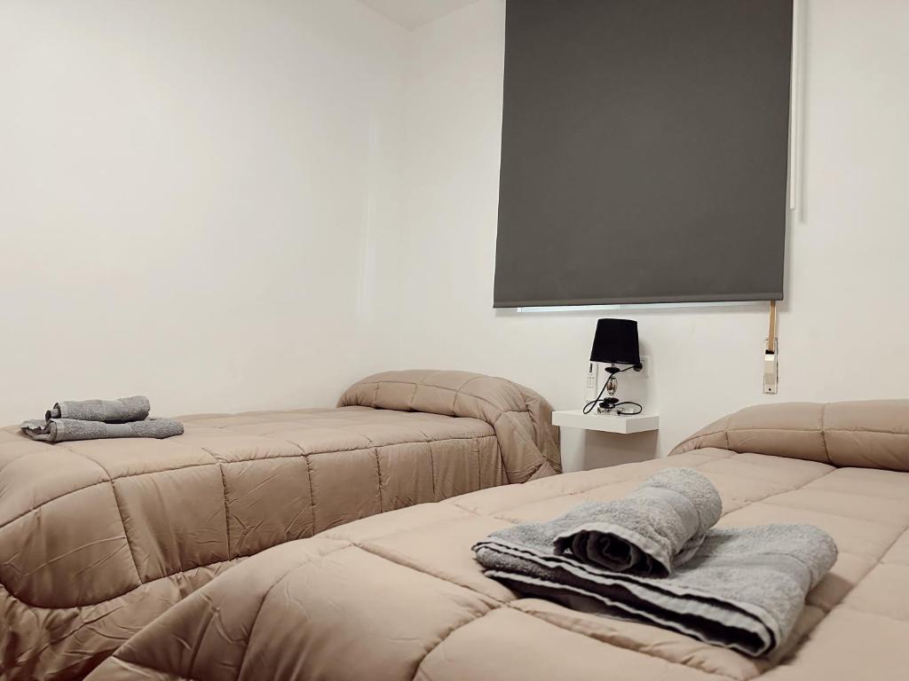 Habitación con 2 camas y TV de pantalla plana. en Apartamentos Maria, en Málaga