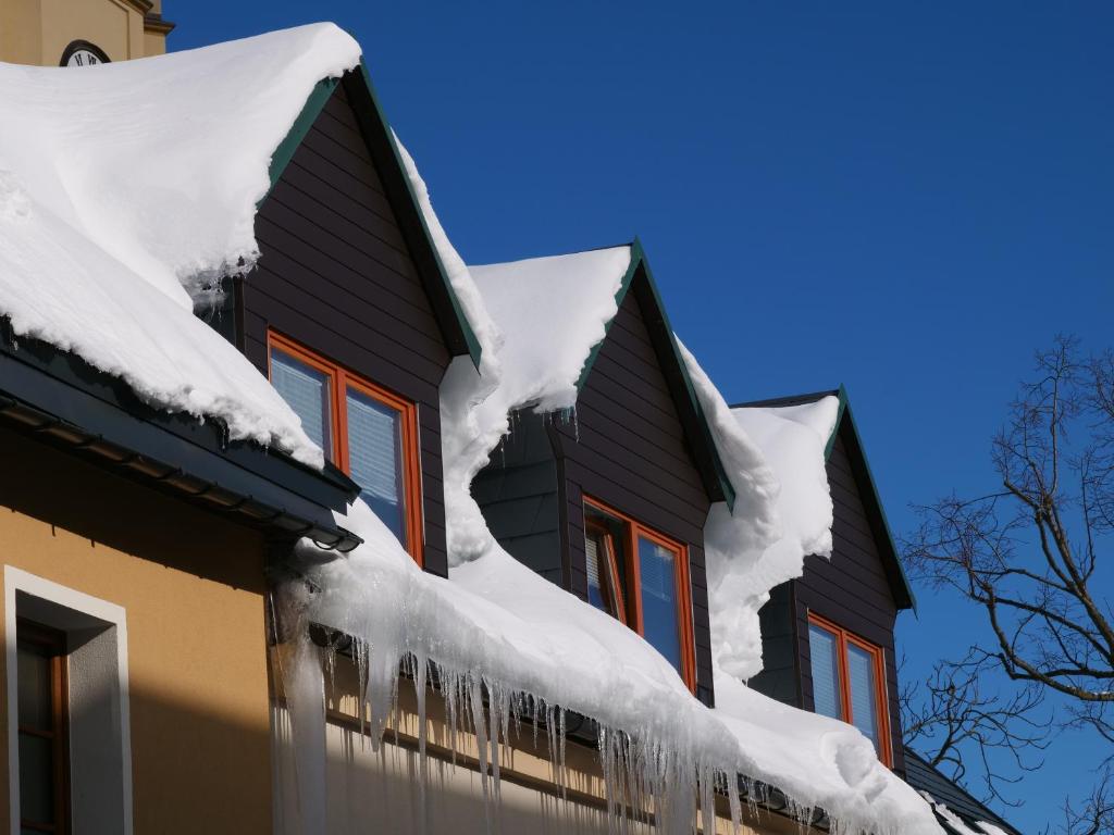 a house covered in snow with icicles on it at Ferienvermietung Engelstädter in Kurort Oberwiesenthal