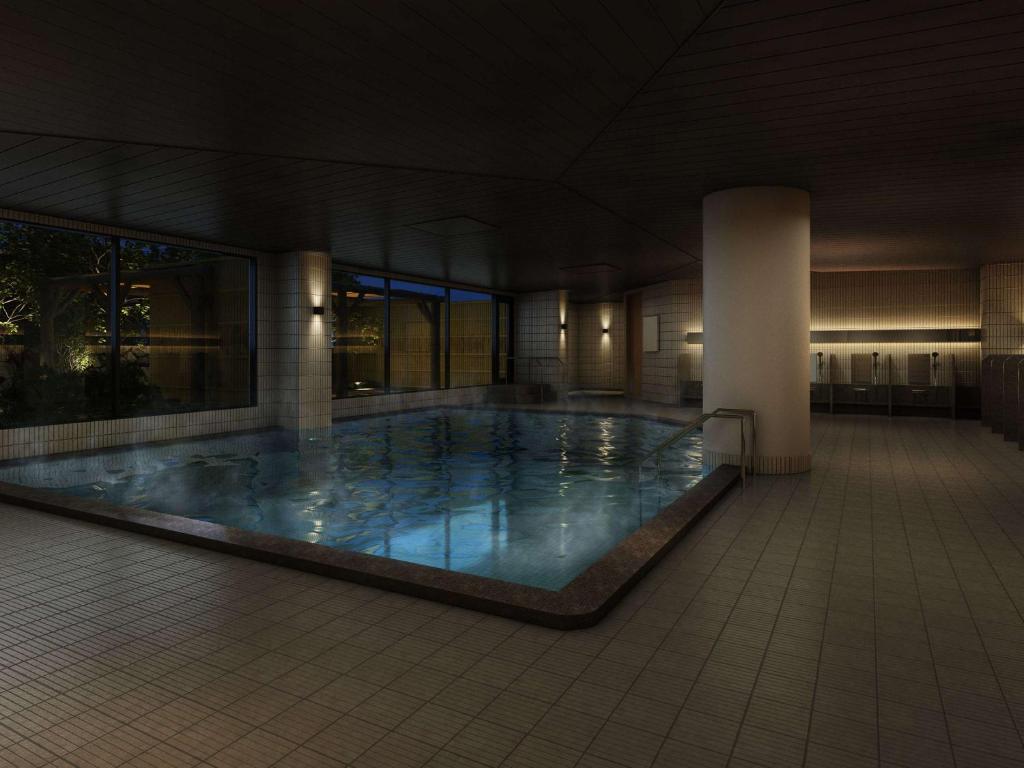 een groot zwembad in een gebouw 's nachts bij Grand Mercure Awaji Island Resort & Spa in Minamiawaji