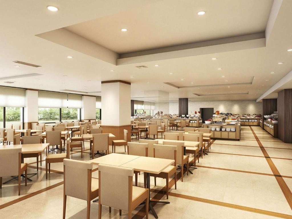 ein Bild eines Restaurants mit Tischen und Stühlen in der Unterkunft Mercure Noto Resort & Spa in Shika