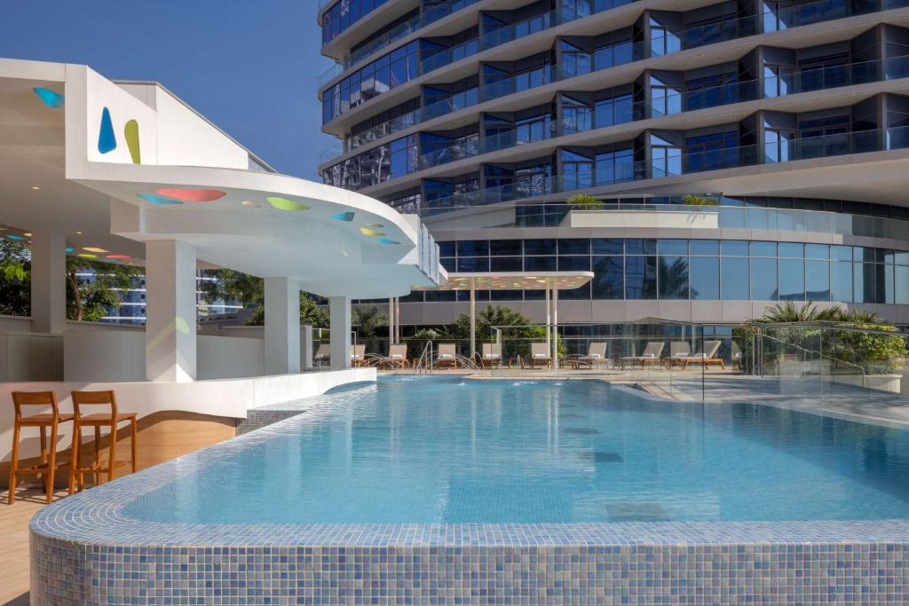 a large swimming pool in front of a building at Hilton Dubai Creek Hotel & Residences in Dubai