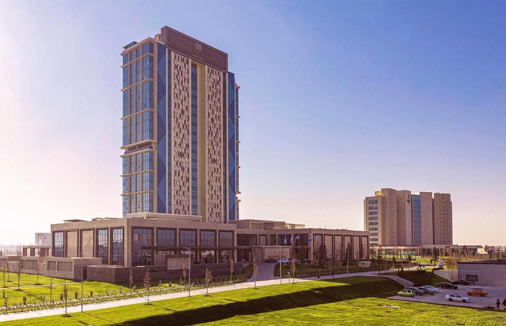 ein hohes Gebäude mitten in einer Stadt in der Unterkunft Hilton Samarkand Regency in Samarkand