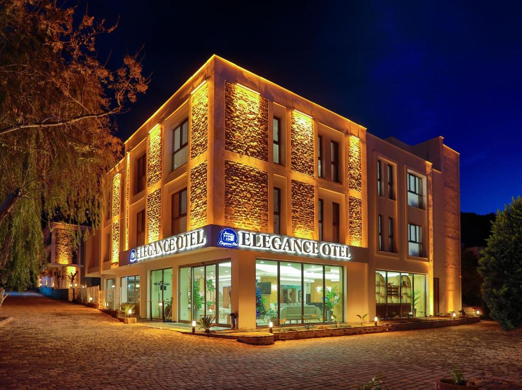 un gran edificio con luces en la parte delantera en Güllük Elegance Otel, en Gulluk