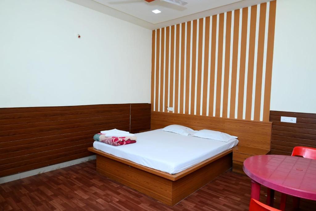a small bedroom with a bed and a table at P P Lodging in Pune