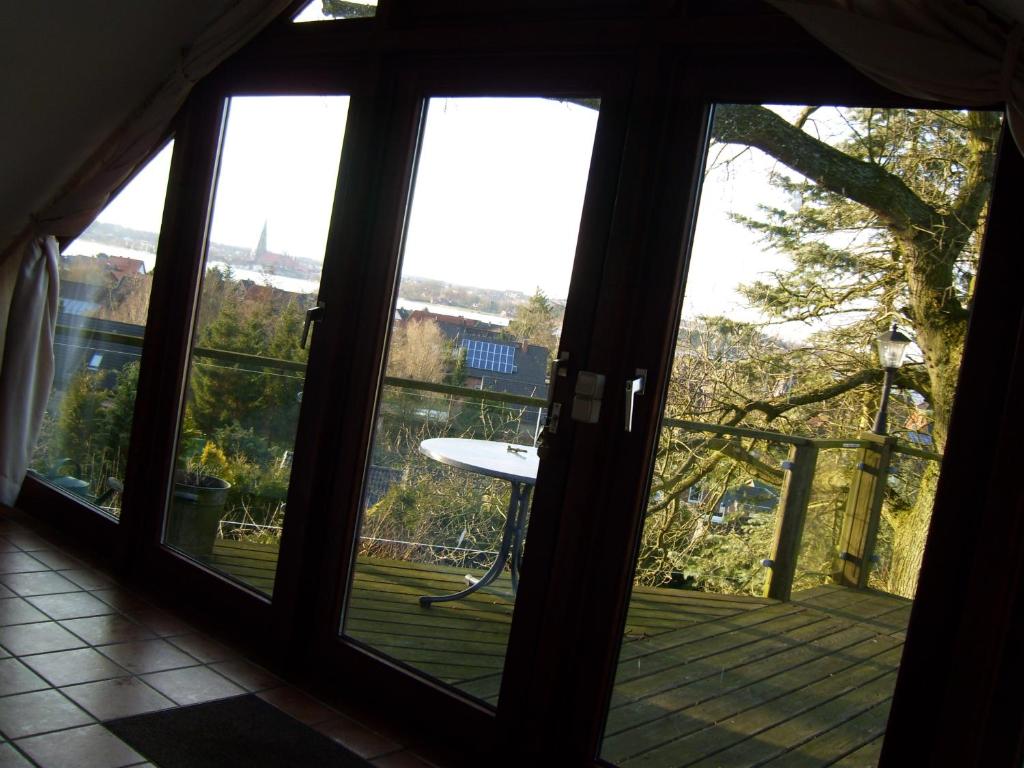 eine offene Tür zu einem Balkon mit einem Tisch auf einer Terrasse in der Unterkunft FeWoFahrdorf in Fahrdorf