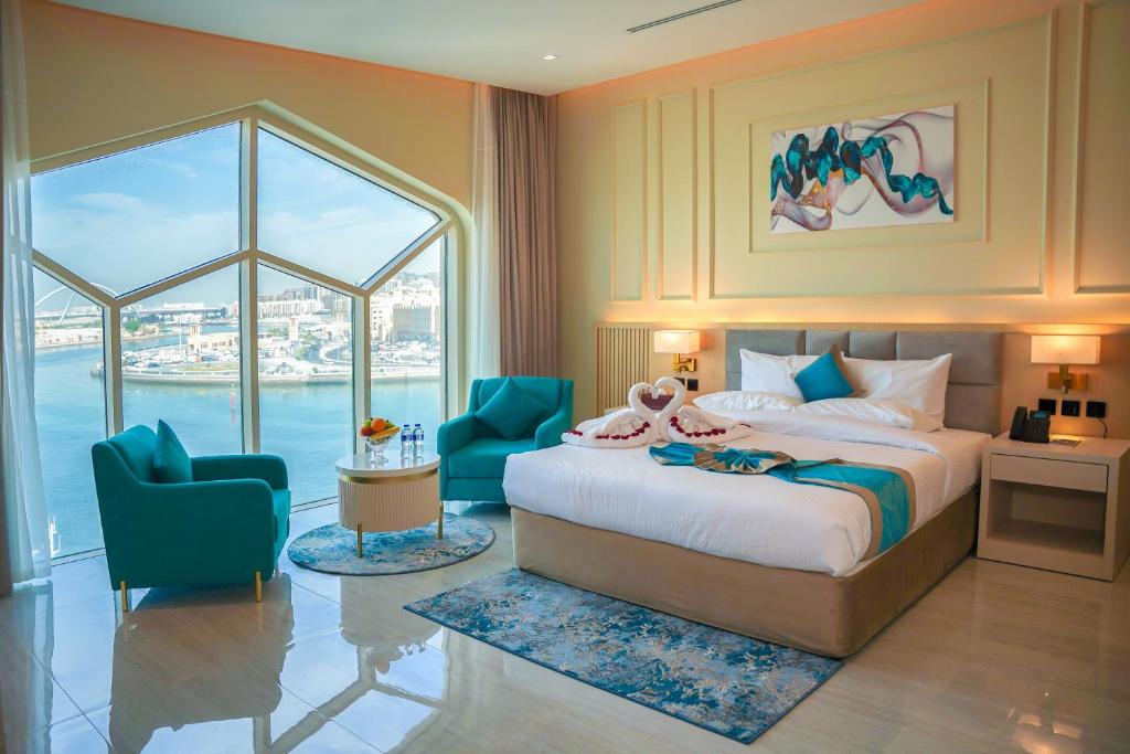 a bedroom with a bed and two blue chairs at Concorde Creek View Hotel Bur Dubai in Dubai