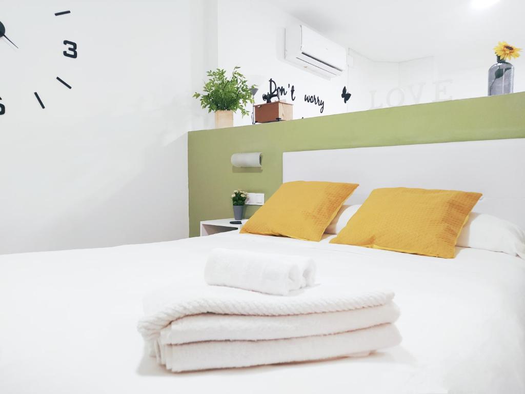 a bedroom with a white bed with towels on it at Apartamento Loft La Magdalena in Córdoba