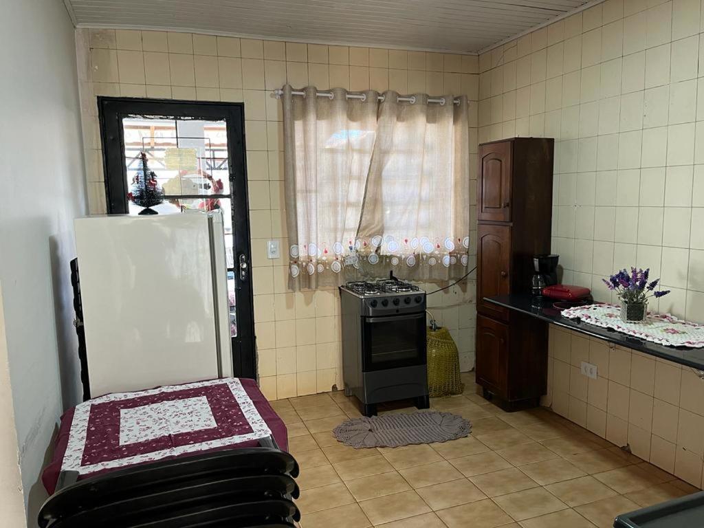 een keuken met een koelkast en een fornuis. bij Casa com 2 quartos agradáveis com ar condicionado in Foz do Iguaçu