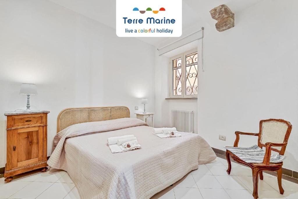 een slaapkamer met een bed en een stoel bij Equilibrium, Terre Marine, Marola in La Spezia