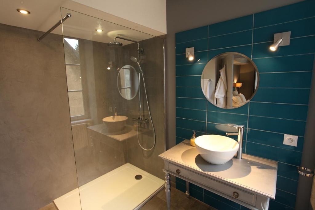 ein Bad mit einem Waschbecken und einer Dusche mit einem Spiegel in der Unterkunft La Berjotine - Maison d'hôtes in Charolles