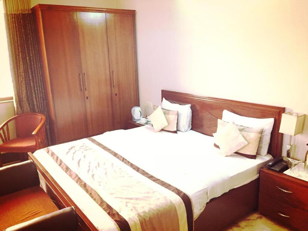 ein Hotelzimmer mit einem Bett und einem Telefon in der Unterkunft Angel NRI House in Greater Noida