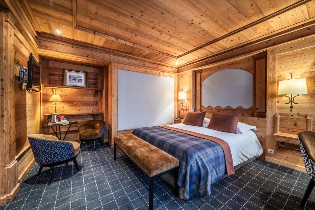 a bedroom with a bed and a table and chairs at Hotel Le Samoyede in Morzine