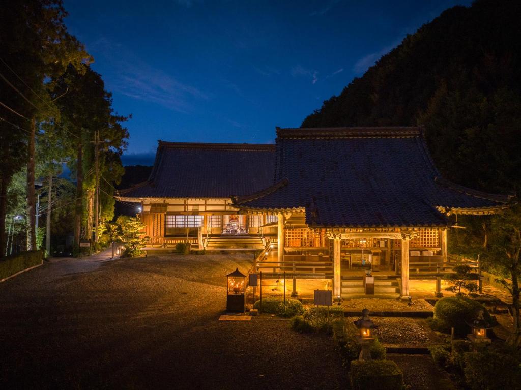 a large wooden building with a roof at night at 宿坊 大泰寺 Temple Hotel Daitai-ji in Shimosato