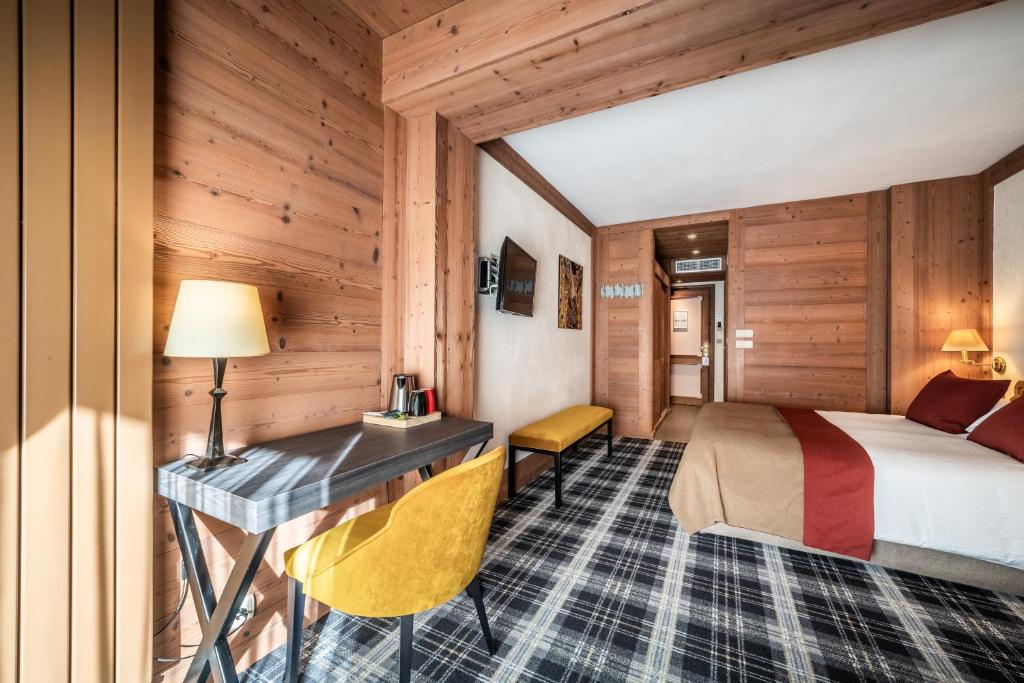 a hotel room with a bed and a desk at Hotel Le Samoyede in Morzine