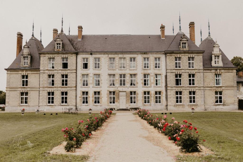 un antico castello con le rose davanti di Château de Vitry-la-Ville a Vitry-la-Ville