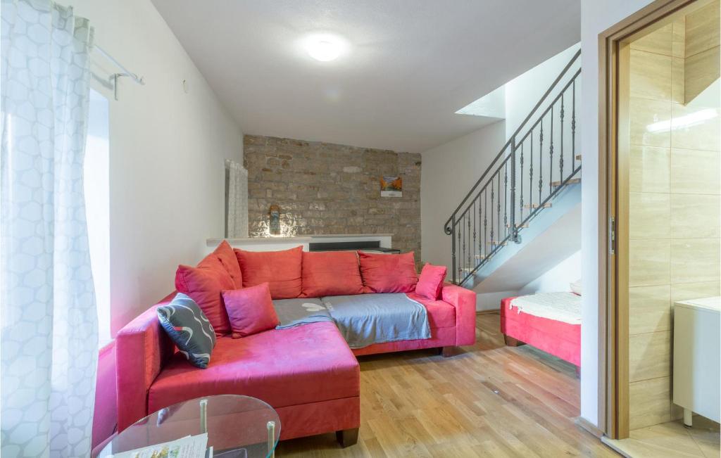 a living room with a pink couch and stairs at 2 Bedroom Stunning Home In Bale in Bale