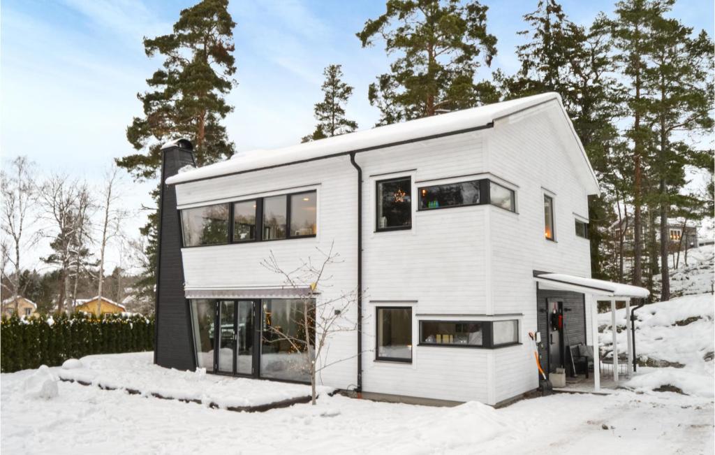 una casa blanca en la nieve en Nice Home In Vrmd With Kitchen, en Värmdö