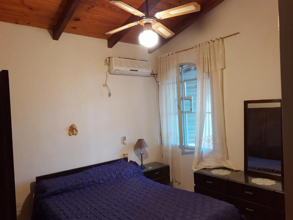una camera con letto blu e ventilatore a soffitto di Alquiler Corral de Bustos a Corral de Bustos