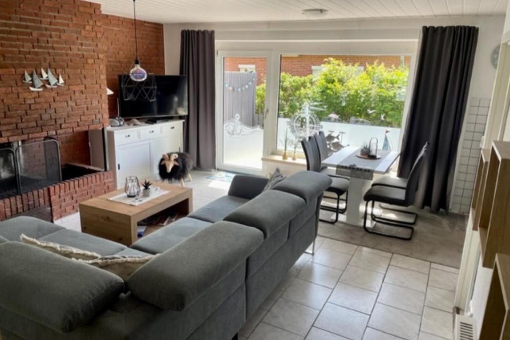 a living room with a couch and a table at !!!NEU!!! Bungalow Juist in Norddeich 150 m vom Strand in Norddeich