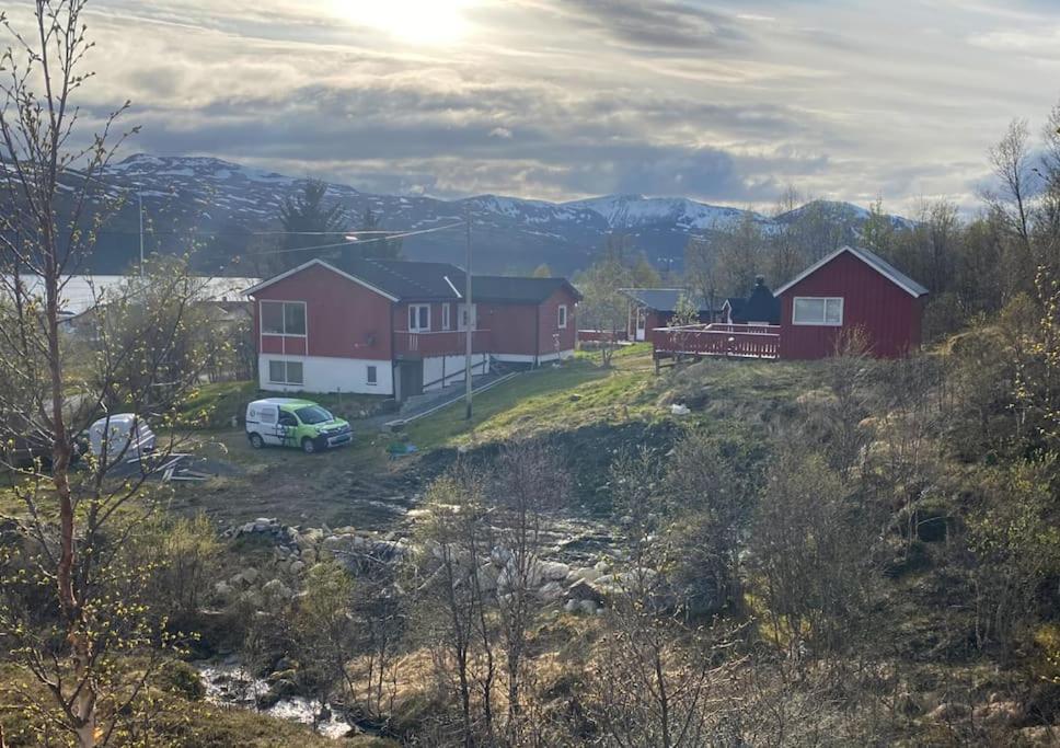 a house on a hill with a car parked in front at Aurora House Dåfjord/Tromsø in Karlsøy