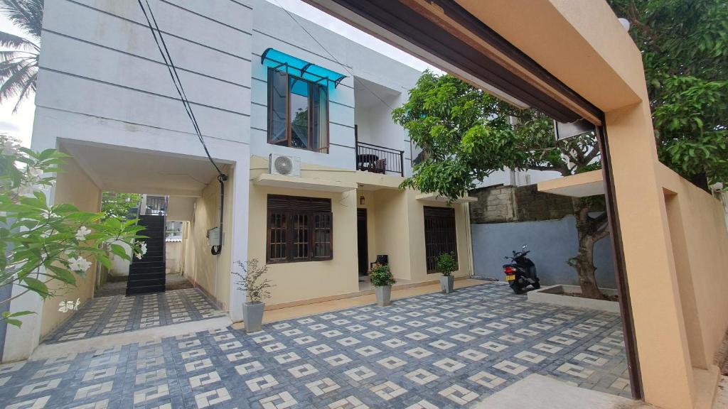 a building with a motorcycle parked in front of it at Nirmali Resort in Mirissa