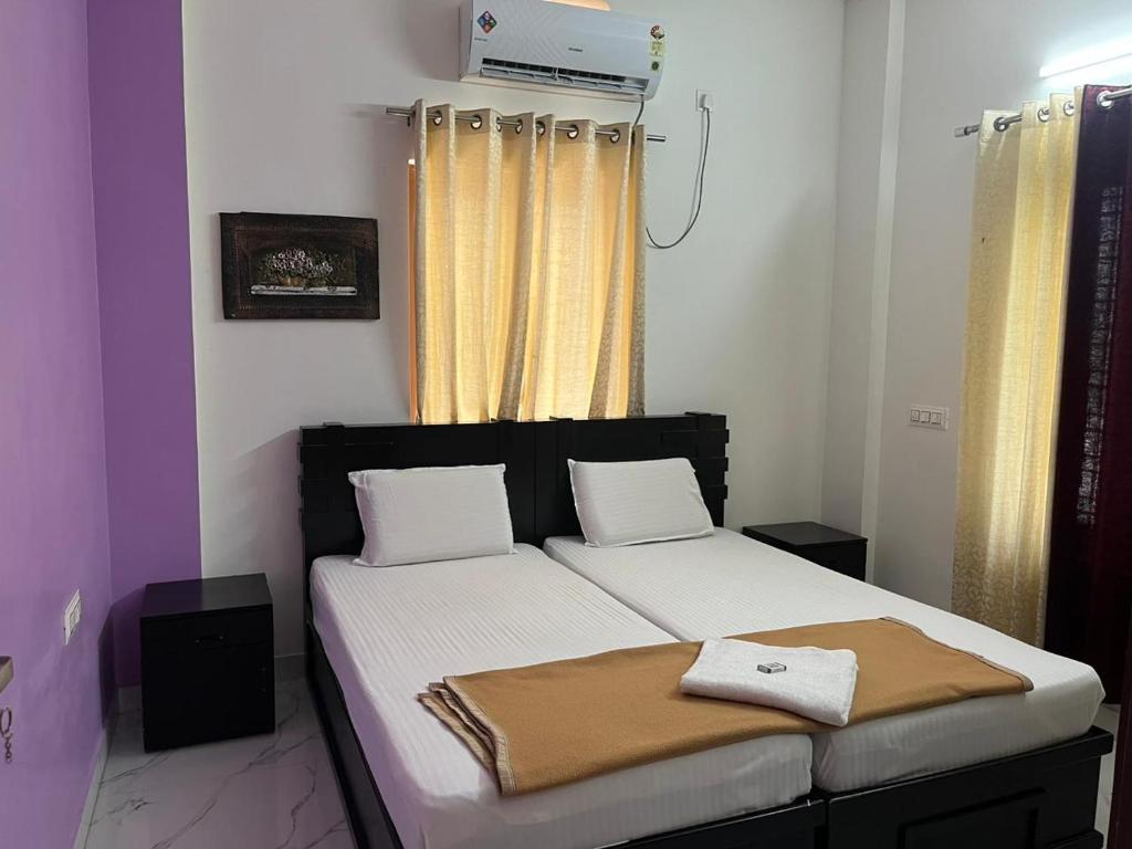 a bedroom with a bed with white sheets and a window at Raha homes in Trivandrum