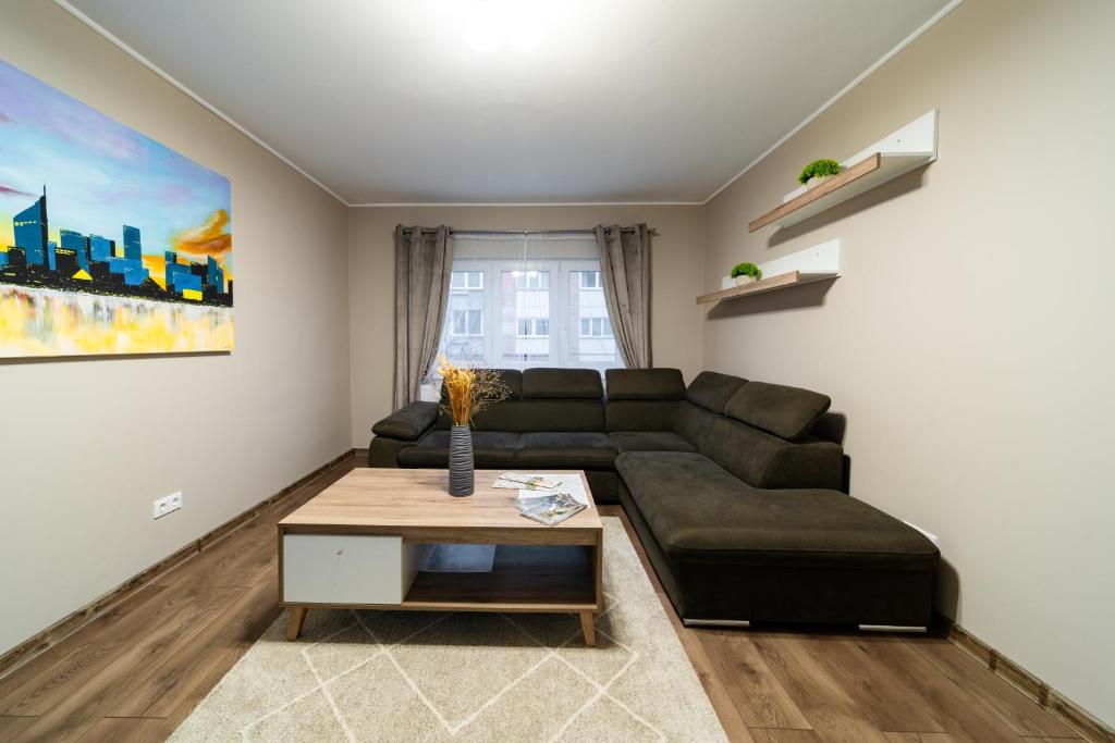 ein Wohnzimmer mit einem Sofa und einem Tisch in der Unterkunft L&H Apartment in Odorheiu Secuiesc