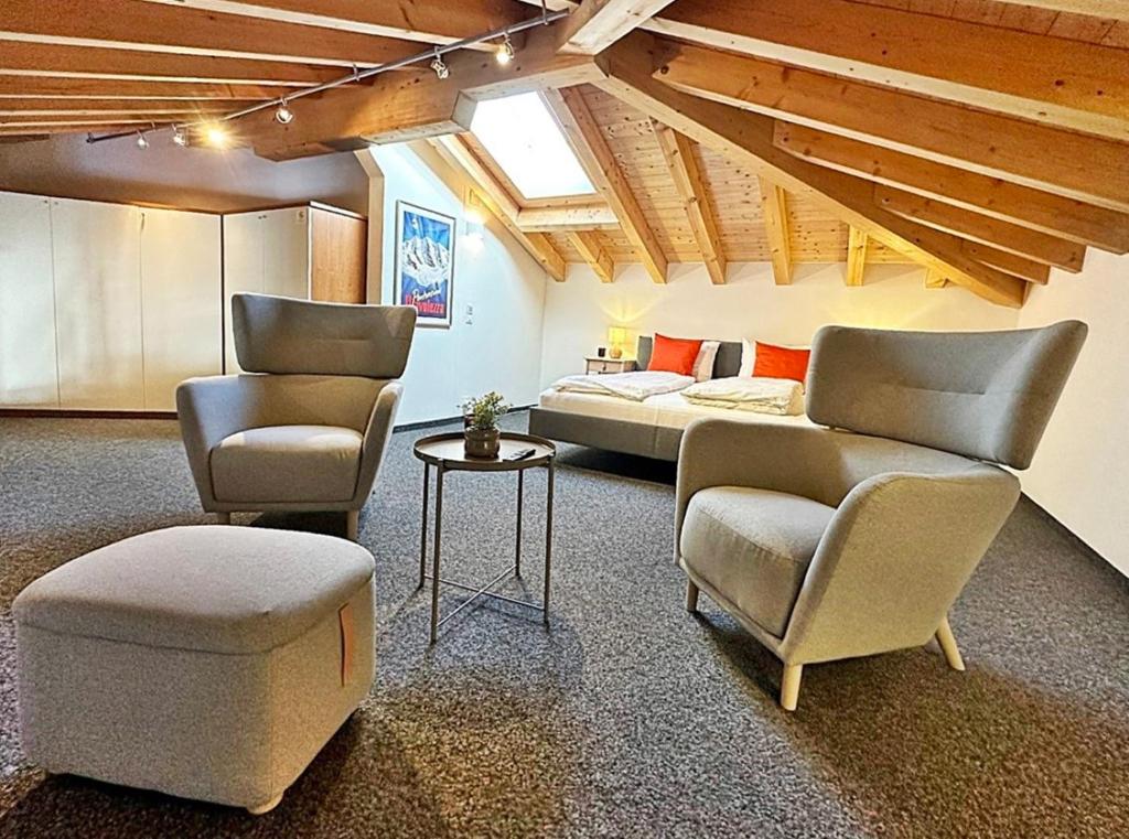 um quarto com 2 cadeiras, uma cama e uma mesa em Maisonette: 45m2 zum Relaxen, 2 Pers./GP - ME17-B em Pontresina