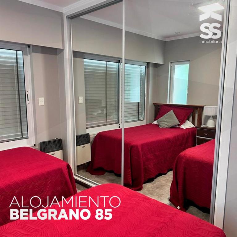 a hotel room with two beds and a mirror at BELGRANO 85 in Libertador San Martín