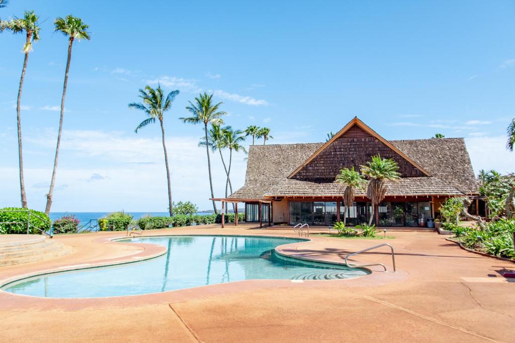 un complejo con piscina y palmeras en Kepuhi Beach Resort, en Maunaloa